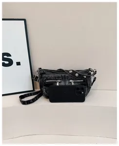 Minimalist washed denim shoulder bag shown with a smartphone for size scale comparison