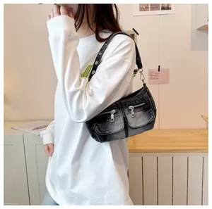 Stylish washed black denim shoulder bag with twin front pockets worn by a model