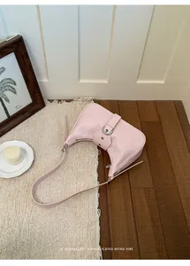 Bolso de hombro retro rosa claro minimalista con detalle de hebilla metálica.