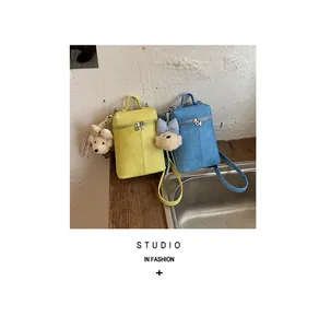 Set of yellow and blue mini bucket crossbody bags with cute puppy charms in a studio