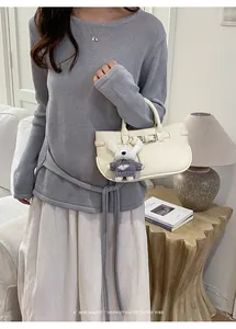 Chic cream minimalist handbag with a cute plush bunny charm in a lifestyle setting