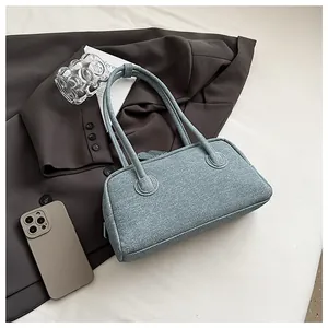 Close-up detail of a blue denim texture Boston bag featuring reinforced shoulder straps.