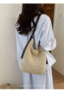 Sac à bandoulière en paille tisseé au style rétro minimaliste porté par un mannequin