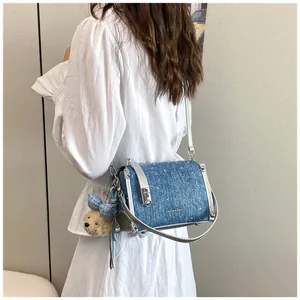 Stylish blue denim crossbody bag with silver star sparkles and cute teddy bear charm.