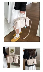 Detailed views of a large cream canvas bag with stone charms and shoulder strap