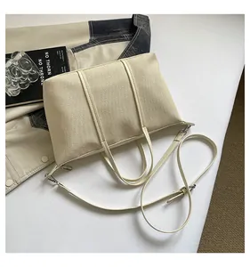 Top view of a large beige canvas tote bag with adjustable shoulder strap and PU trim