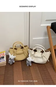 Scenario display showing cream and yellow commuter bucket bags with bear charms
