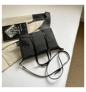 Detailed macro view of dark grey large capacity canvas tote bag with black leather straps.
