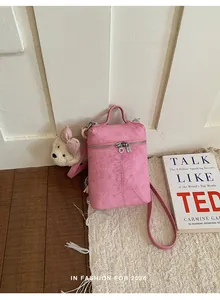 Stylish pink textured mini bucket bag featuring a cute white teddy bear charm accessory