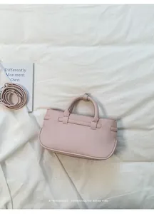 Detailed view of a pink pebbled leather handbag featuring a minimalist design style.