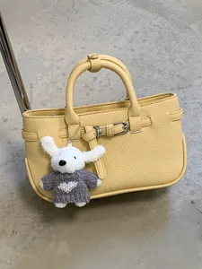 Chic yellow lychee grain handbag featuring a cute white dog plush keychain accessory