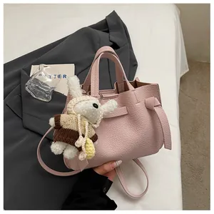 Sac cabas élégant en cuir rose avec charm lapin en peluche dans un décor lifestyle