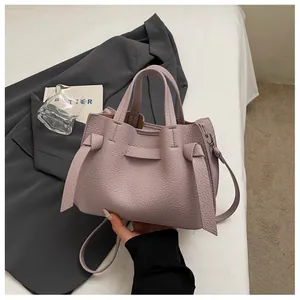 Vue détaillée d'un élégant sac cabas en cuir texturé mauve avec des détails de nœuds