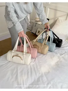 Multiple colors of elegant vintage-style cylindrical women's handbags in a lifestyle setting.