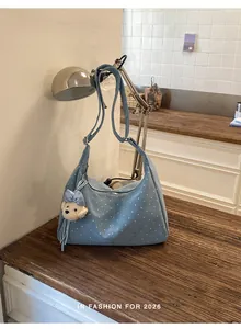 Stylish light blue polka dot tote bag with a cute bear charm on a rustic wooden table