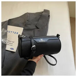 Detailed view of a chic black cylinder crossbody bag with silver zipper and strap.