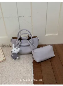 Close-up of lavender textured leather bucket bag with matching pouch and bunny charm.