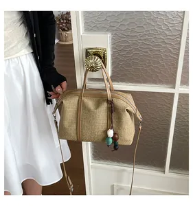 Casual khaki canvas handbag hanging on a golden door handle in a lifestyle setting