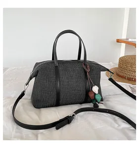 Casual large charcoal canvas handbag with decorative pebble charm and shoulder strap