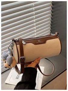 Macro detail of the stylish canvas cylinder crossbody bag with brown leather trim