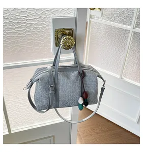 Minimalist grey canvas crossbody bag hanging on a vintage door handle in a room