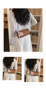Back view of a woman wearing a brown cylindrical crossbody bag with a cute bear charm