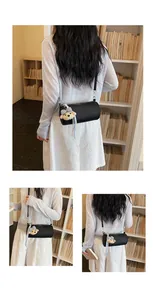 Lifestyle detail of a black cylindrical crossbody bag with a cute bear plush charm