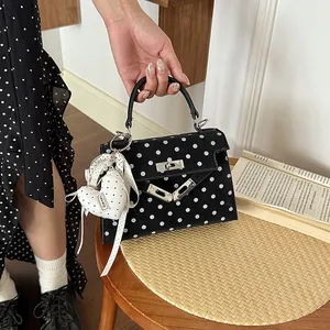 Black and white polka dot square handbag with heart charm for daily commute