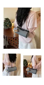 Chic grey cylinder crossbody bag with cute teddy bear pendant shown on model in life style