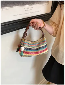 Détail d'un sac à main en paille tressée arc-en-ciel avec lanière marron pour les vacances