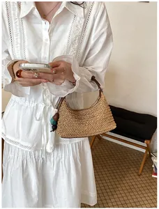 Gros plan d'un sac à bandoulière en paille fait main pour les vacances d'été.