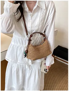 Sac hobo en paille tressée sur mannequin en robe blanche pour un look de plage