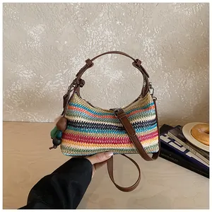 Vue détaillée d'un sac à bandoulière en paille rayée arc-en-ciel pour vacances à la plage