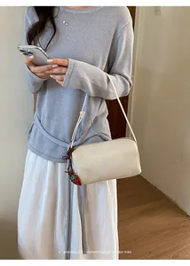 Minimalist beige retro pillow shoulder bag with a cute strawberry pendant detail