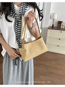 Detail view of elegant beige woven underarm bag styled with a vintage women's outfit.