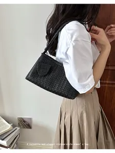 Detailed view of woven leather texture on an elegant black vintage underarm bag