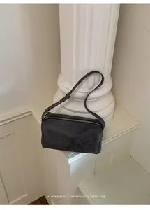 Close-up of a minimalist retro pillow bag with a sophisticated textured finish.