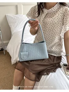 Close-up of a light blue woven leather underarm bag in an elegant vintage style