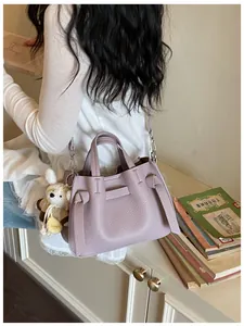 Sac à main chic en cuir grainé lilas avec breloque ours dans un cadre de vie élégant