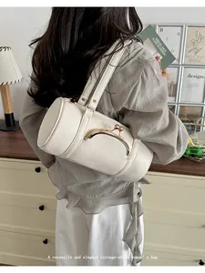 Elegant white cylindrical vintage underarm bag with a golden kiss-lock metal closure