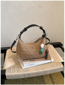 Détail montrant la texture du sac en paille tressée avec des ornements en perles