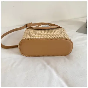 Vue détaillée du fond du sac seau en paille tissé à la main avec base en cuir marron