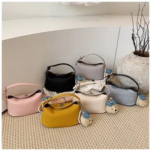 Elegante collezione multicolore di borse a mano in denim e pelle con ciondoli a orsetto.