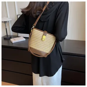 Elegante borsa a secchiello intrecciata a mano con finiture in pelle per la spiaggia.