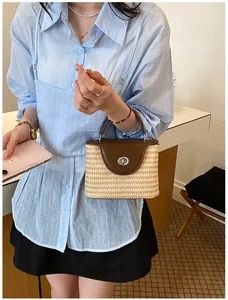 Détail d'un élégant sac seau en paille tissé à la main pour femme avec rabat en cuir