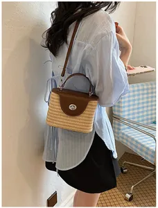 Détail d'un sac seau en paille tissé à la main avec rabat en cuir marron pour plage