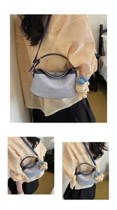 Elegante borsa a tracolla in denim blu con ciondolo a forma di orso sulla spalla