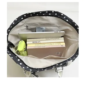 Interior view of large capacity black polka dot tote bag with laptop and books