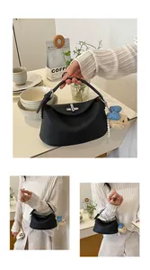 Dettaglio di una borsa a mano nera in pelle martellata con un simpatico ciondolo di peluche
