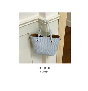 Detailed shot of a light blue woven bucket bag with elegant knot handle details